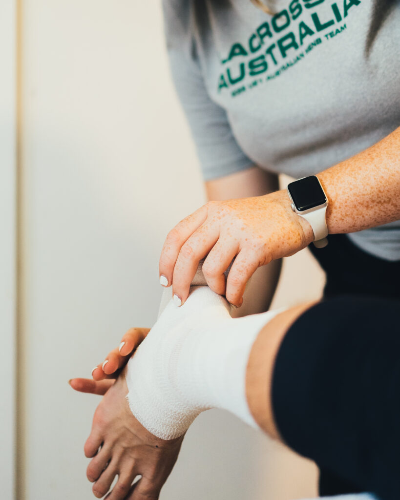 applying sports tape on ankle